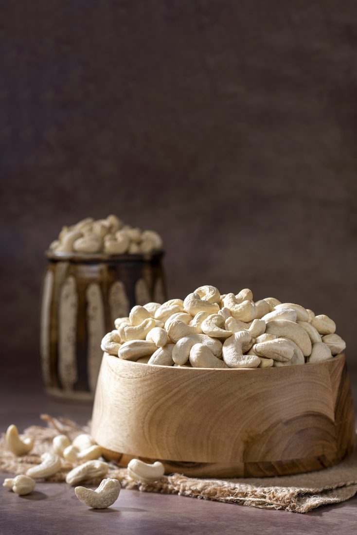 Wooden bowl piled with premium raw cashew nuts